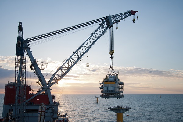 Large crane vessel installing a transformer platform in a windfarm under construction of the UK coast