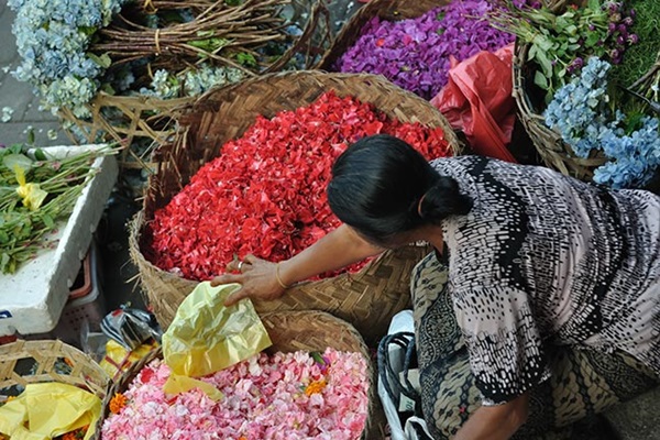 Vrouw op een market met manden met bloemen. Illustratie bij IMVO Convenanten.