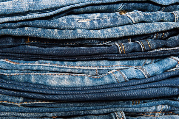 Stapel jeans. Illustratie bij IMVO Convenant Duurzame Kleding en Textiel.