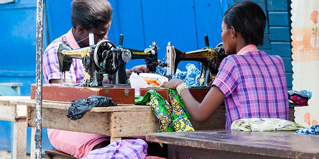 Kleding en textiel. Twee mensen maken kleding op hun naaimachines. Illustratie bij IMVO Convenant Duurzame Kleding en Textiel.